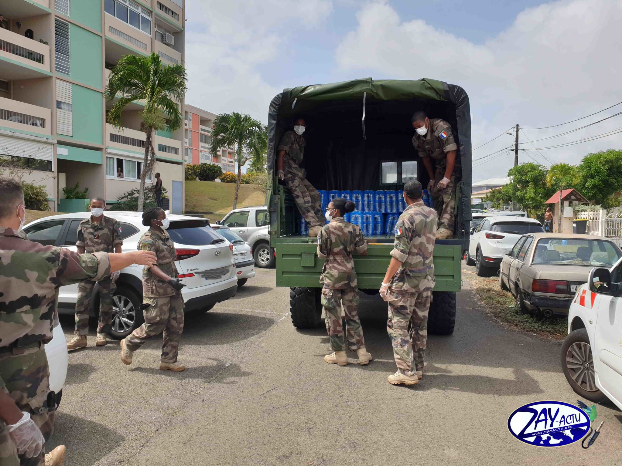 Des militaires qui distribuent des packs d'eau à Saint-James à Acajou Lamentin