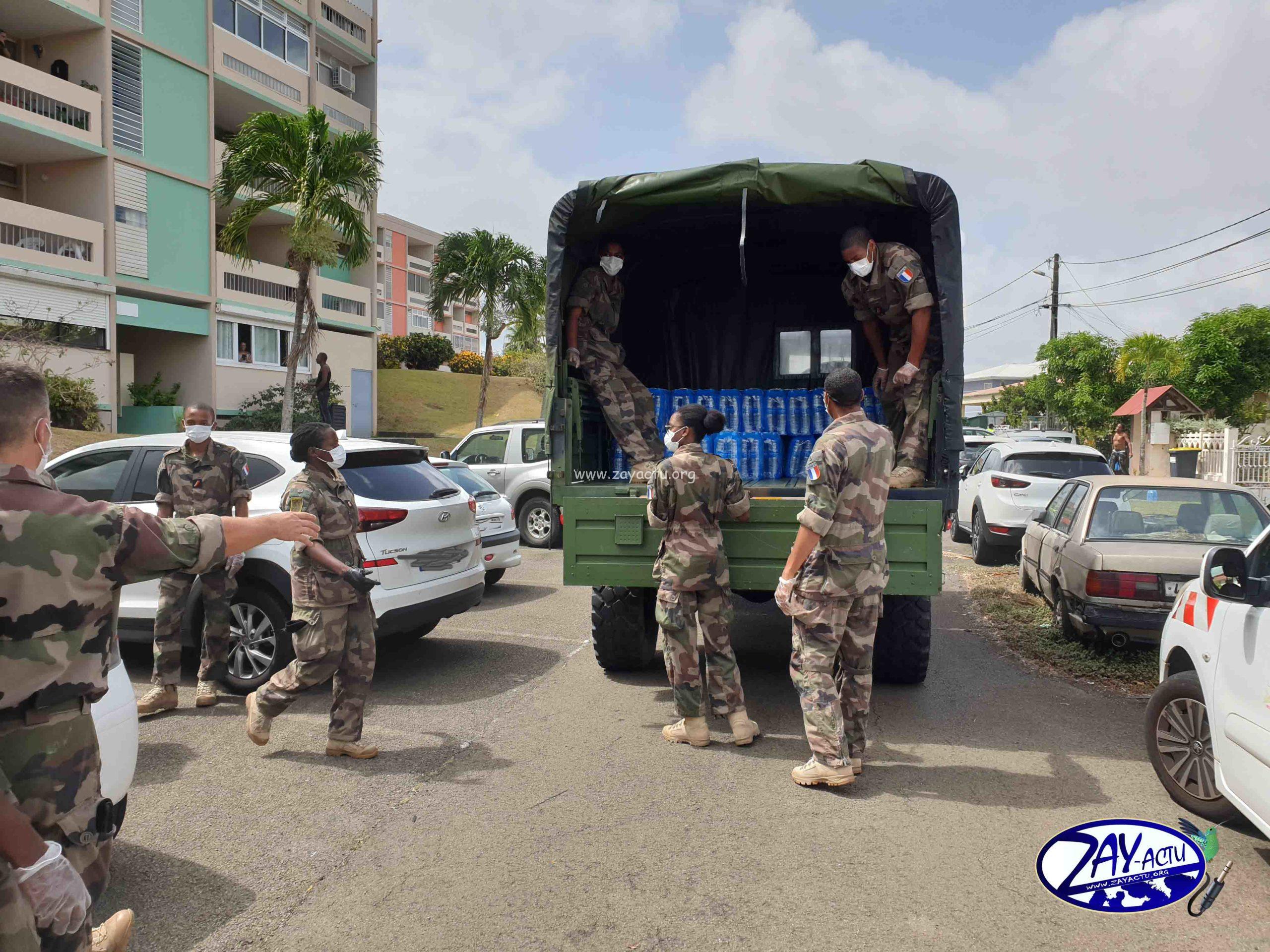 Des militaires qui distribuent des packs d'eau à Saint-James à Acajou Lamentin